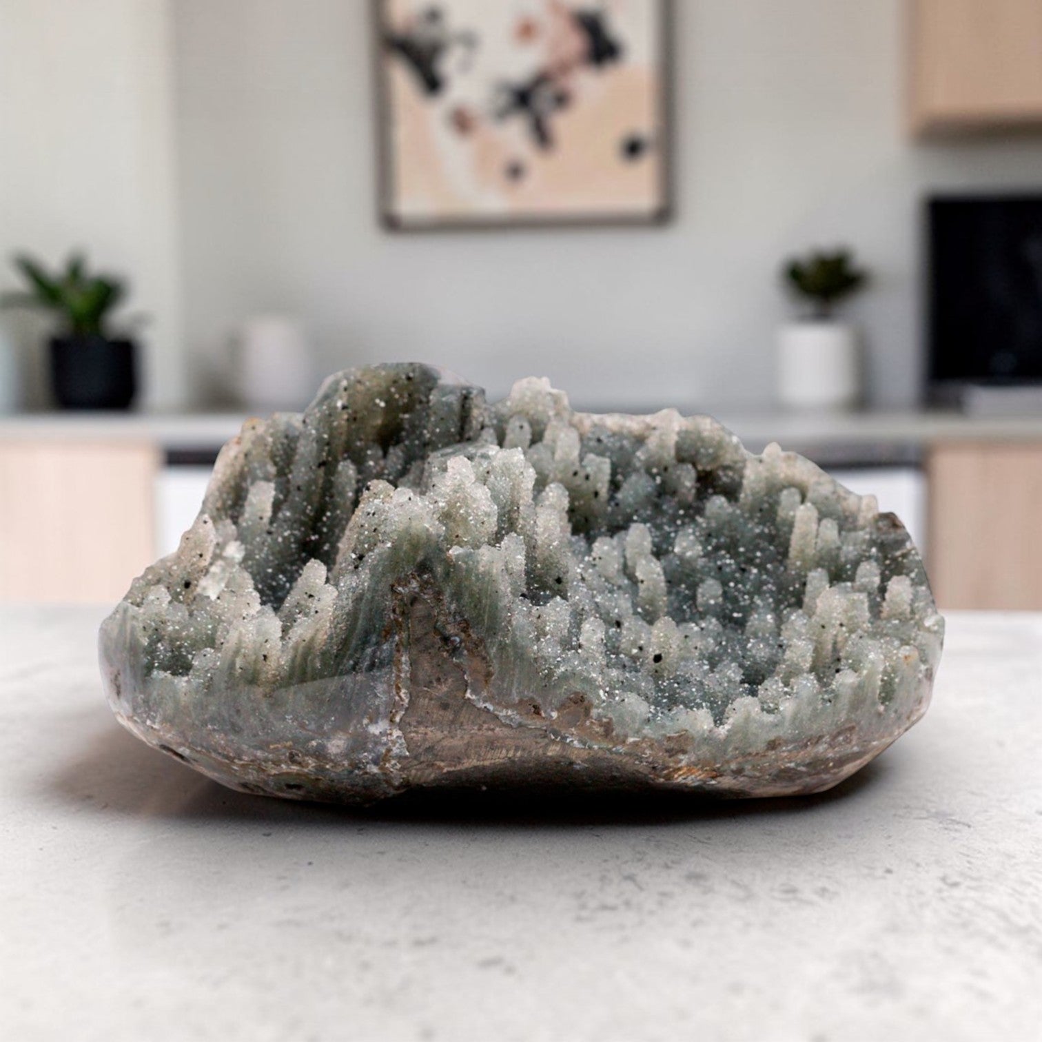 Small natural crystal geode displaying a grey quartz crystal cluster with fine druzy texture, organic chalcedony edges, and a raw mineral silhouette suited for luxury neutral decor.