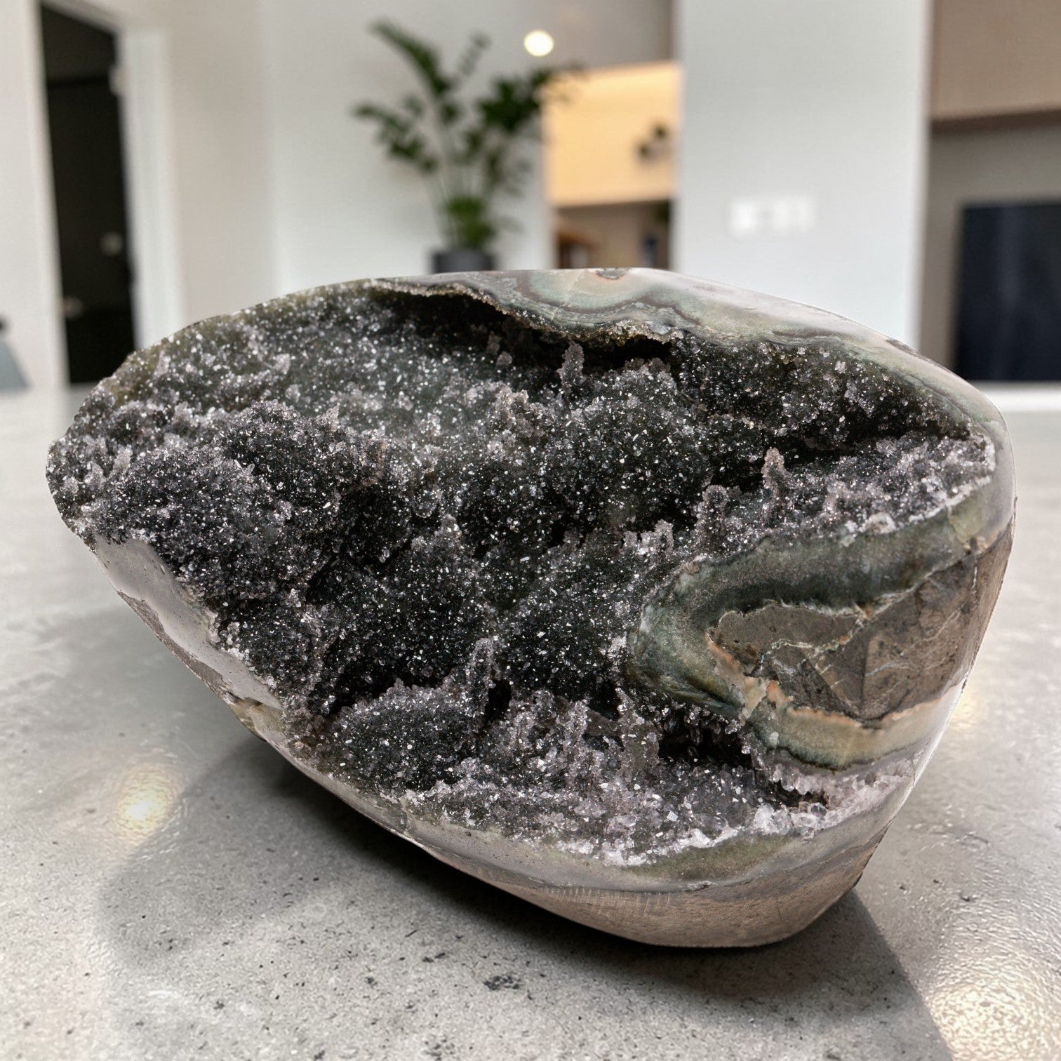 Small natural crystal geode featuring a sparkling charcoal druzy quartz interior, pronounced banded agate layers, and organic volcanic formation cut into a geometric display form.