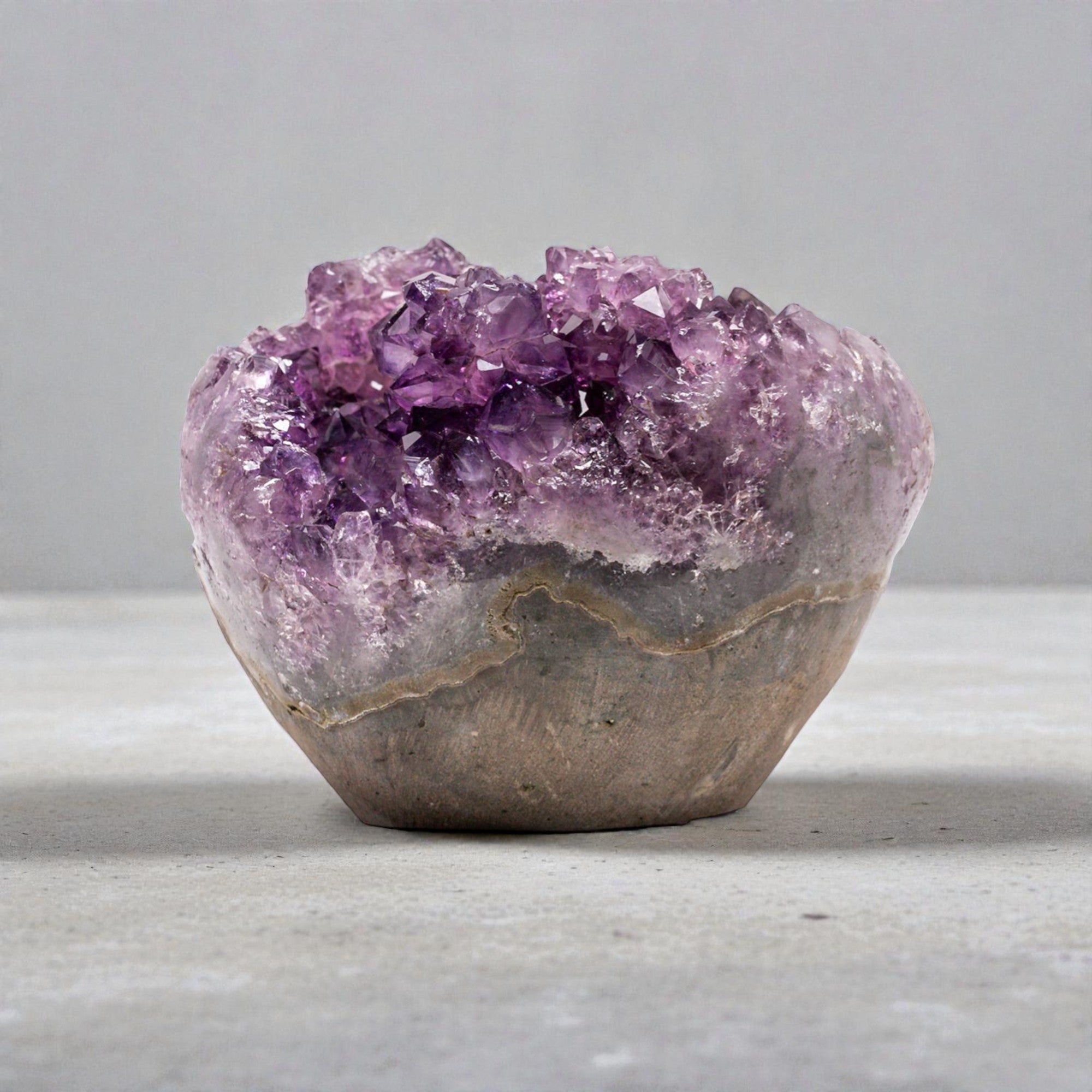 Small natural quartz geode featuring layered agate and a vibrant druzy amethyst interior formed within a volcanic cavity.