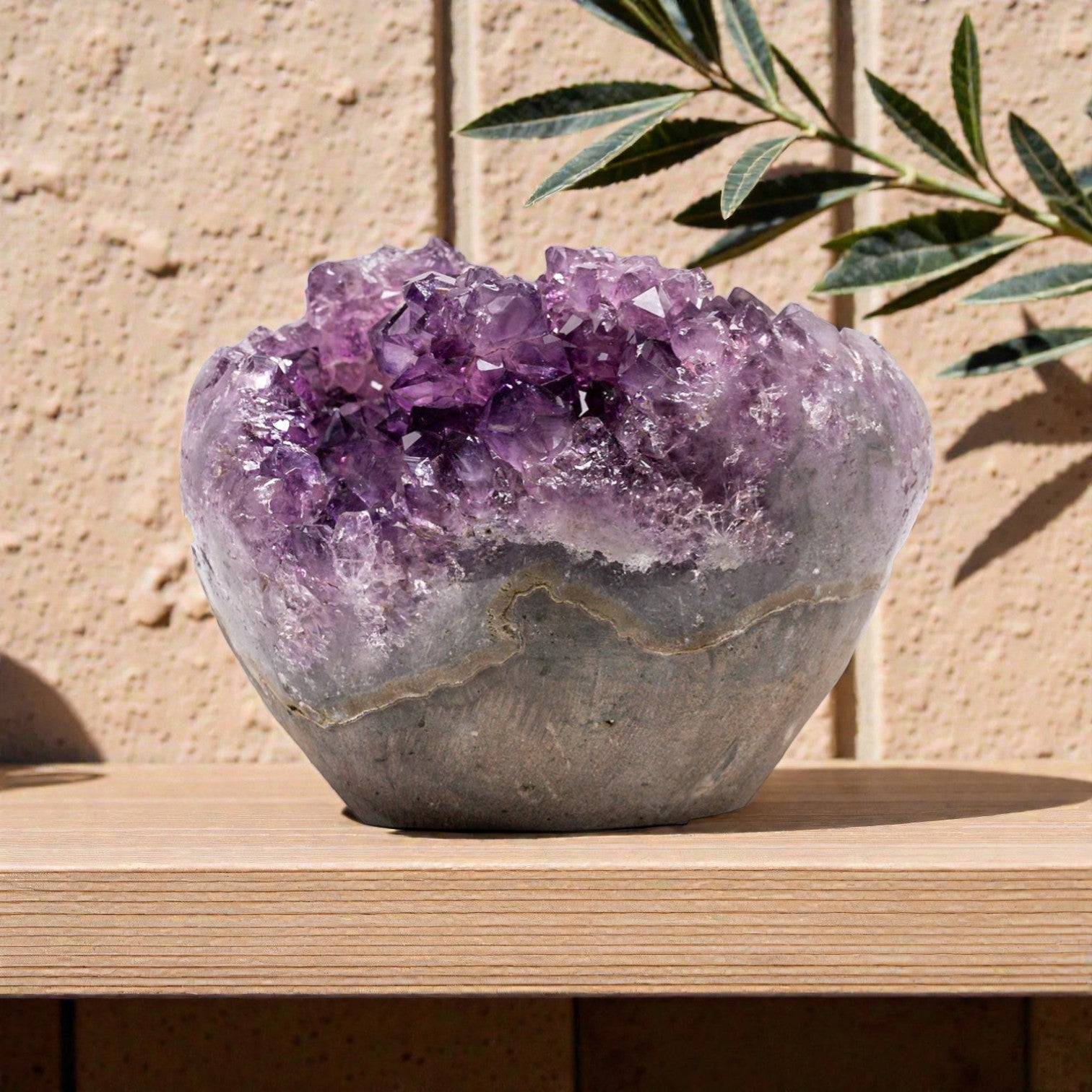 Hand-sized purple amethyst crystal geode showcasing deep violet points and organic mineral banding in a refined display piece.