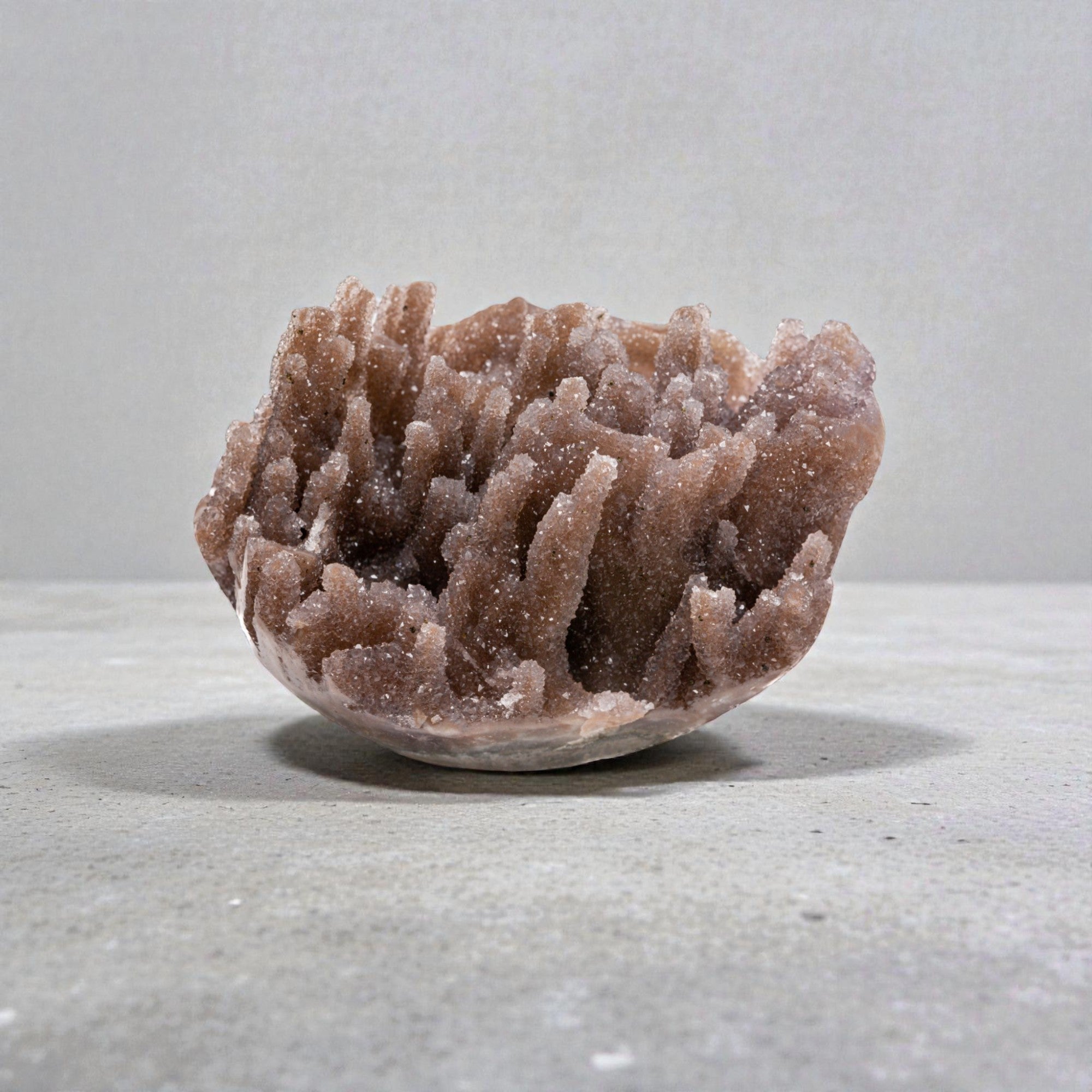 Small natural crystal geode featuring sparkling coral quartz clusters and organic layered chalcedony in a compact display form