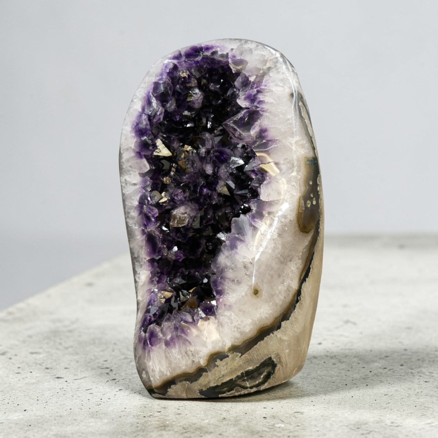 This natural amethyst geode egg is one of the rarest forms a Uruguayan amethyst can take. The egg shape is not cut or carved — it emerges from the rough through careful selection and polishing, preserving the raw crystal interior while revealing a seamless, tactile exterior. At 35.25 lb, it is a true statement amethyst piece: substantial, self-standing, and unmistakably Artigas.