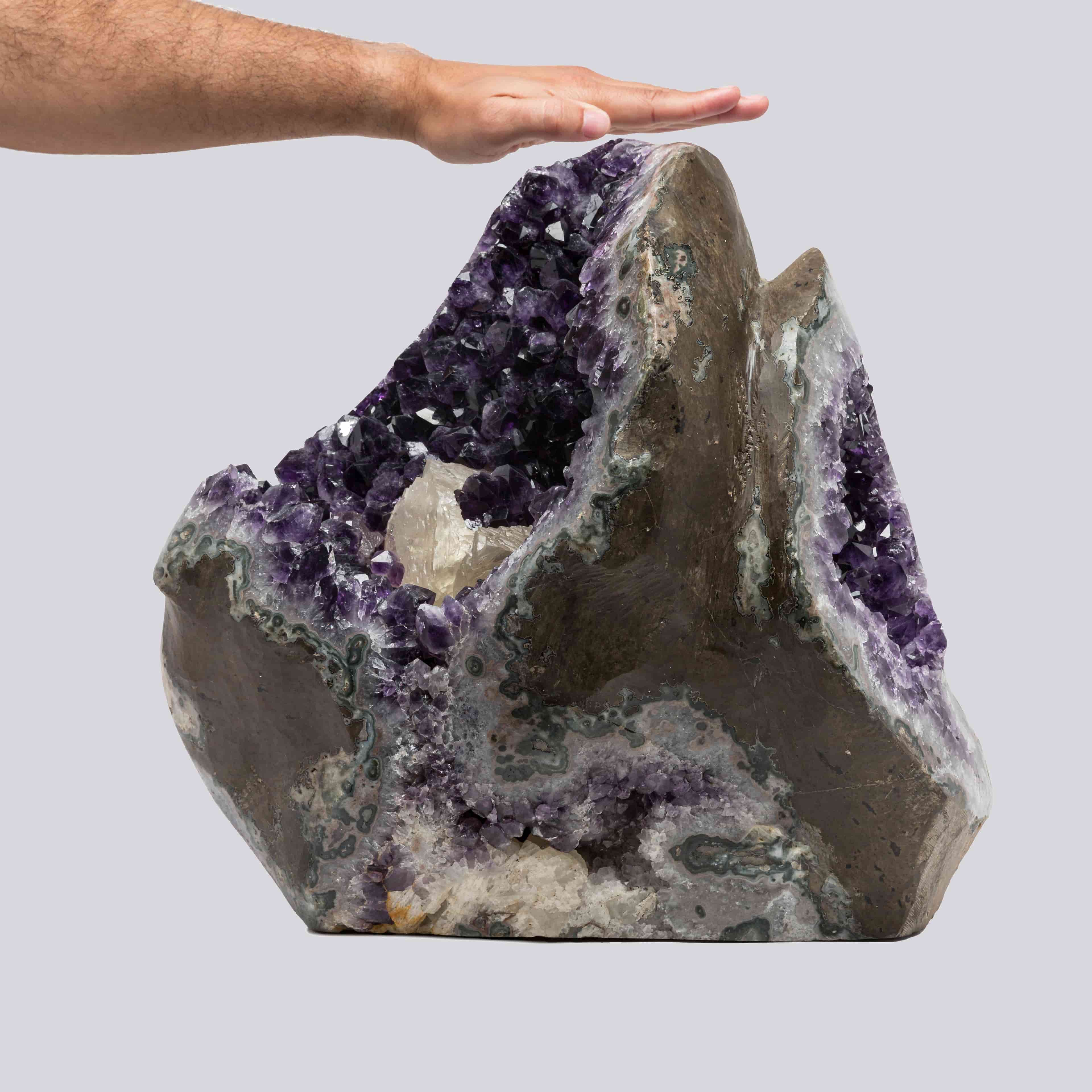 Sculptural Uruguayan amethyst geode with deep purple crystals, green agate banding, and a prominent white calcite formation inside. Gigant.