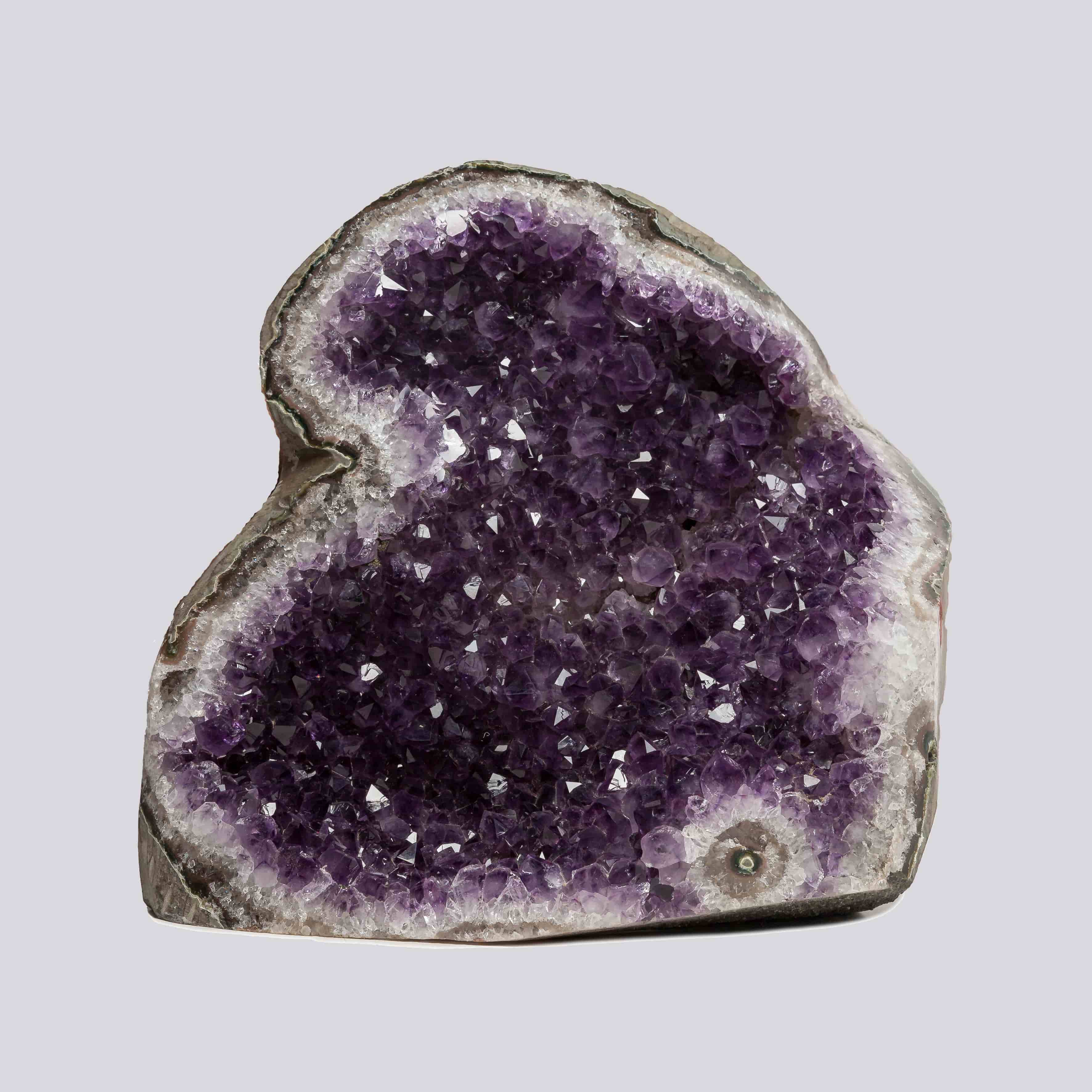 Deep purple Uruguayan amethyst geode with dense crystal formations and white quartz edges, ideal for refined home decor.