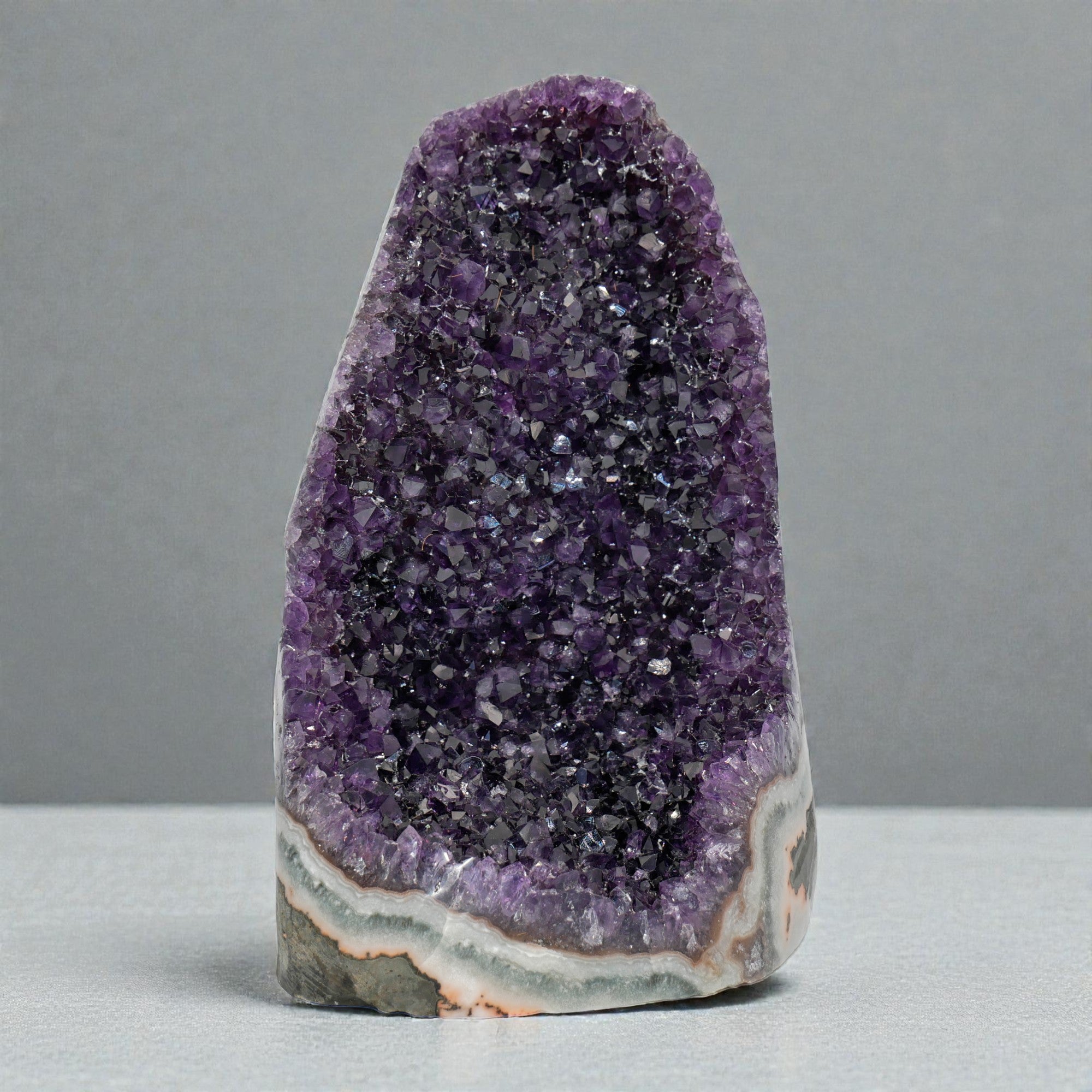 Large amethyst cluster collection displaying cathedral-style purple quartz crystals with layered agate bases, ideal as statement mineral decor pieces.