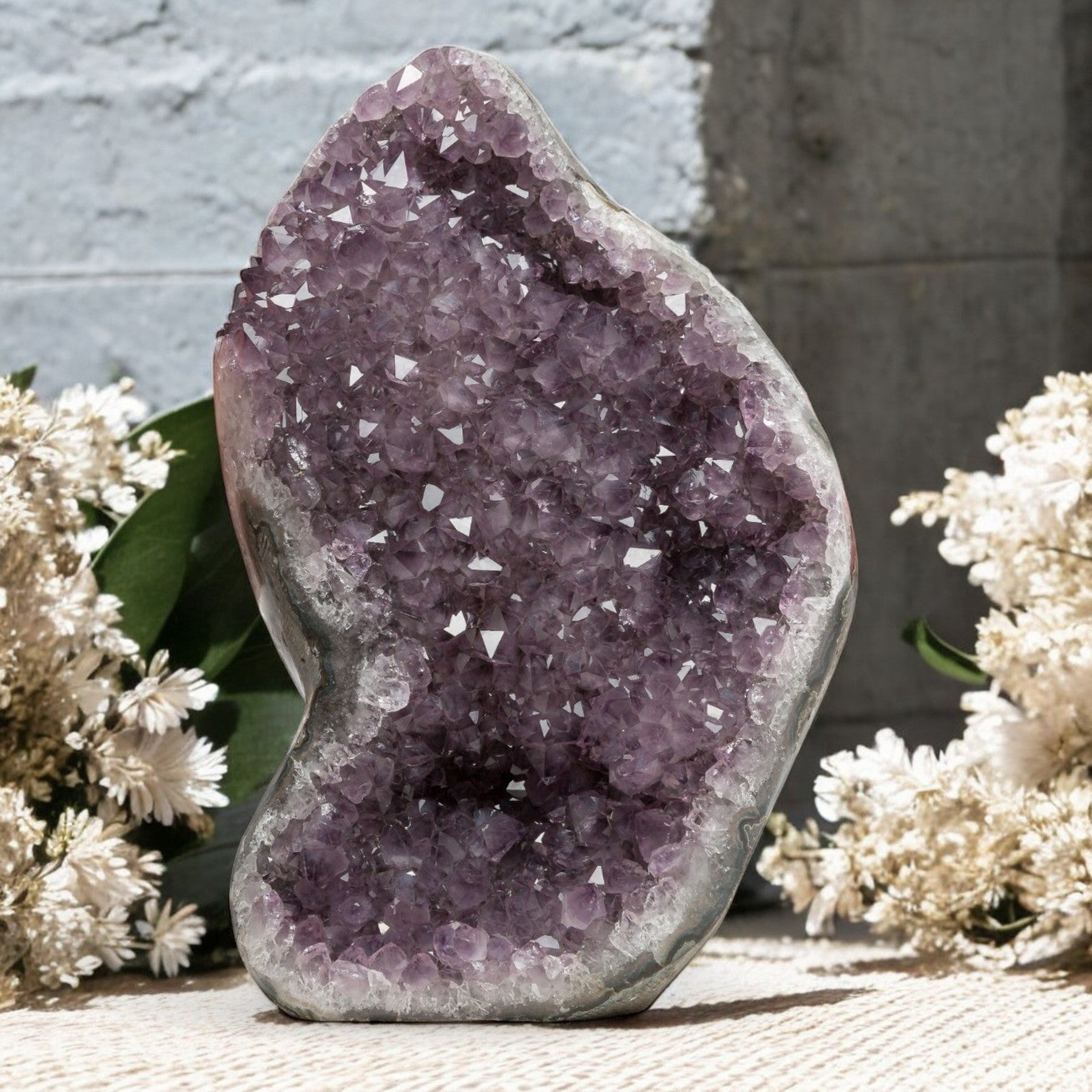 Sculptural amethyst crystal formation featuring pale violet points, curved geode contours, and natural agate-quartz layering.