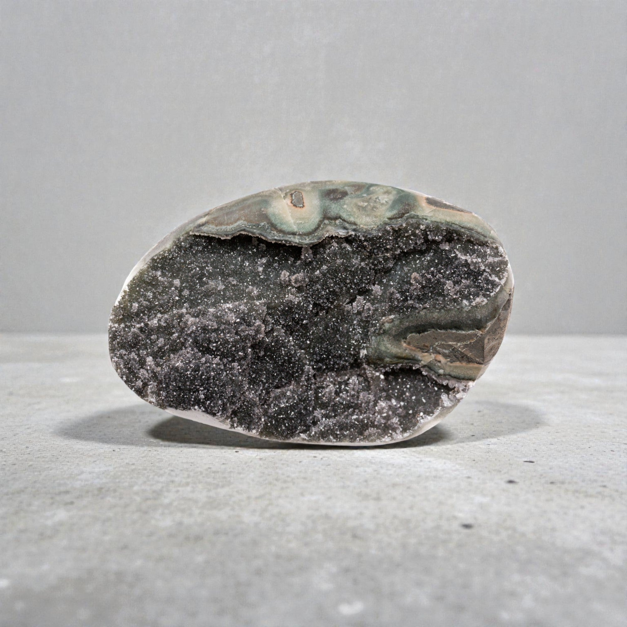 Small natural crystal geode featuring a sparkling charcoal druzy quartz interior, pronounced banded agate layers, and organic volcanic formation cut into a geometric display form.