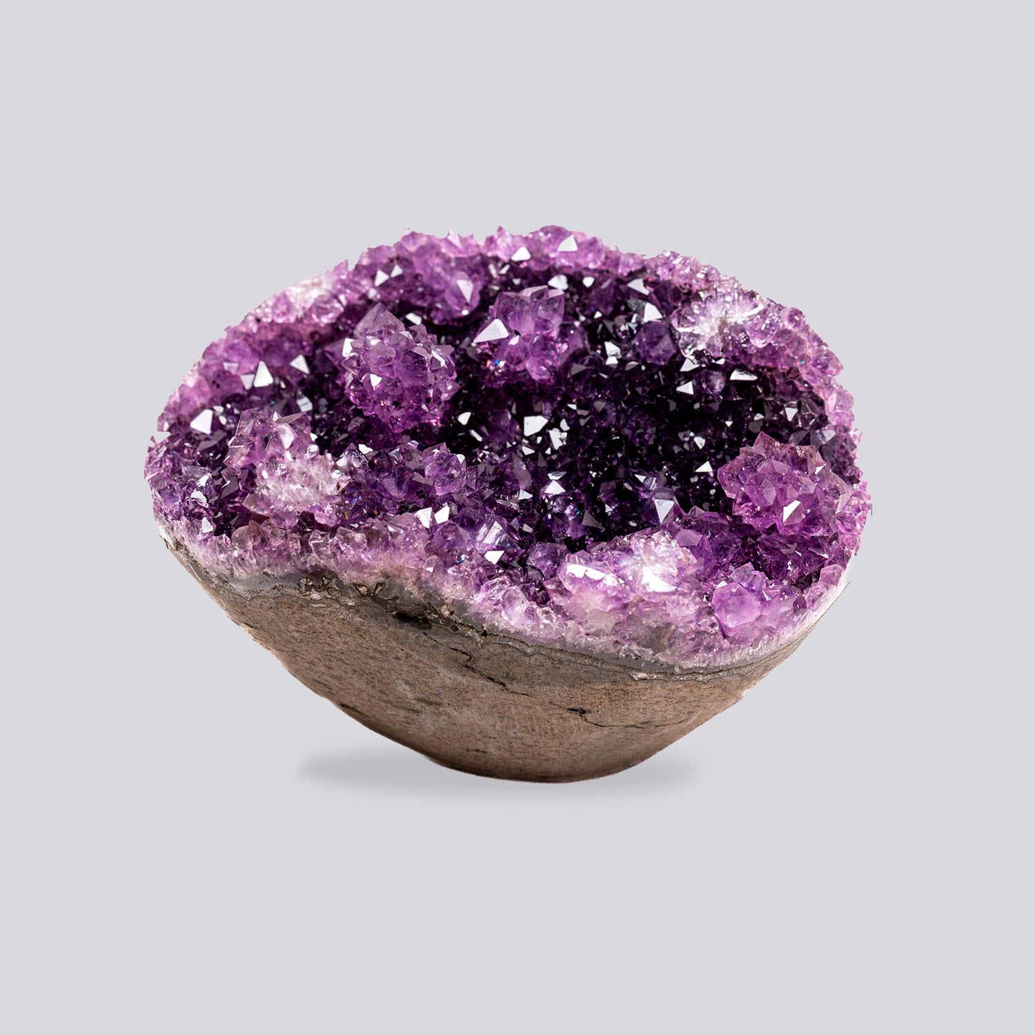 Mini deep purple amethyst geode with high-saturation crystal clusters and sparkling druzy interior, set on a natural polished base.