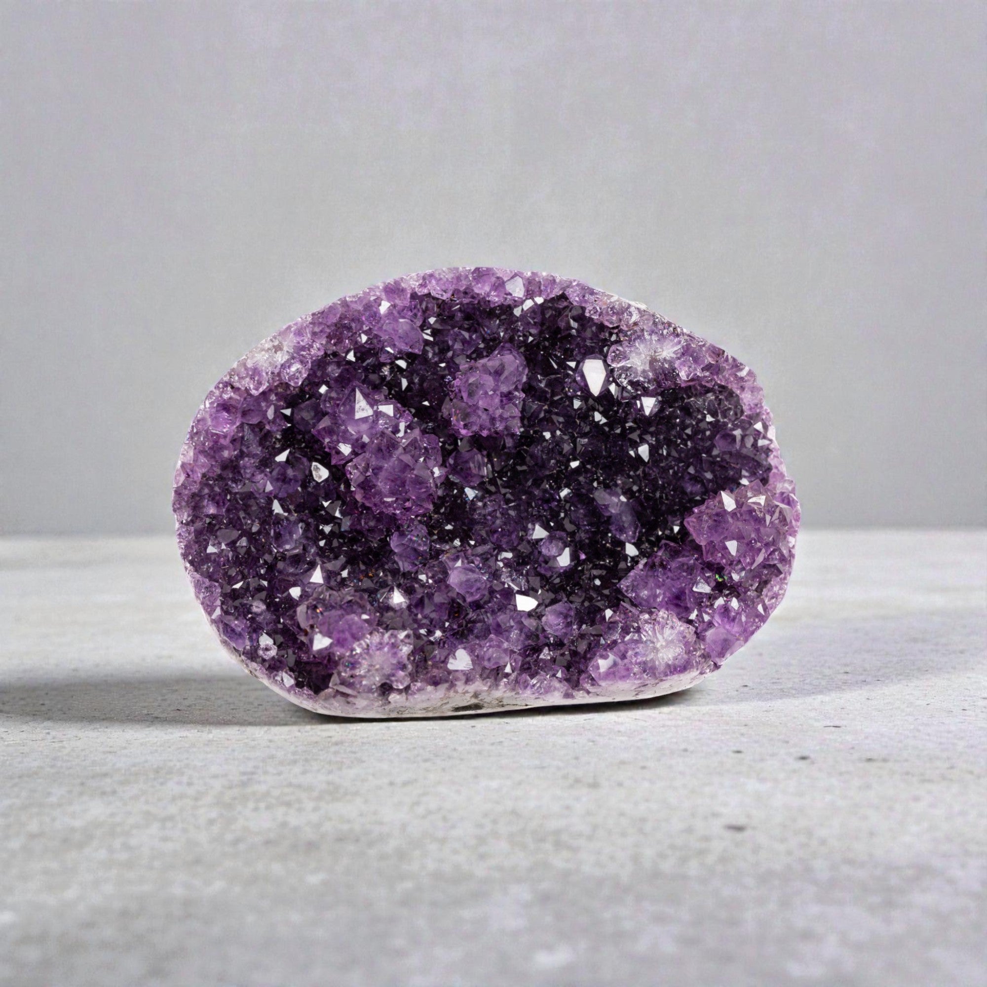 Small amethyst crystal geode featuring vivid violet quartz points formed within a volcanic cavity, displayed in a compact bowl shape.