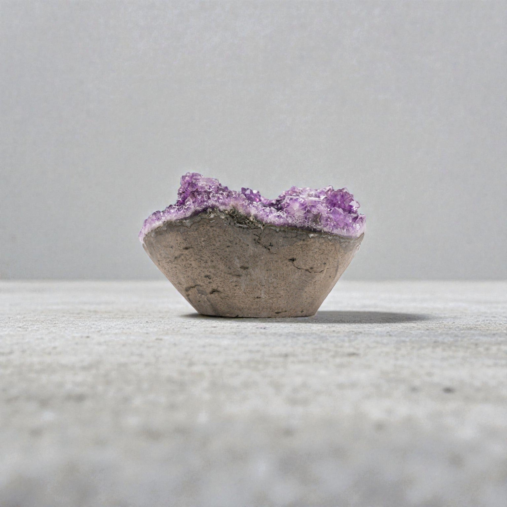 Mini deep purple amethyst geode with high-saturation crystal clusters and sparkling druzy interior, set on a natural polished base.