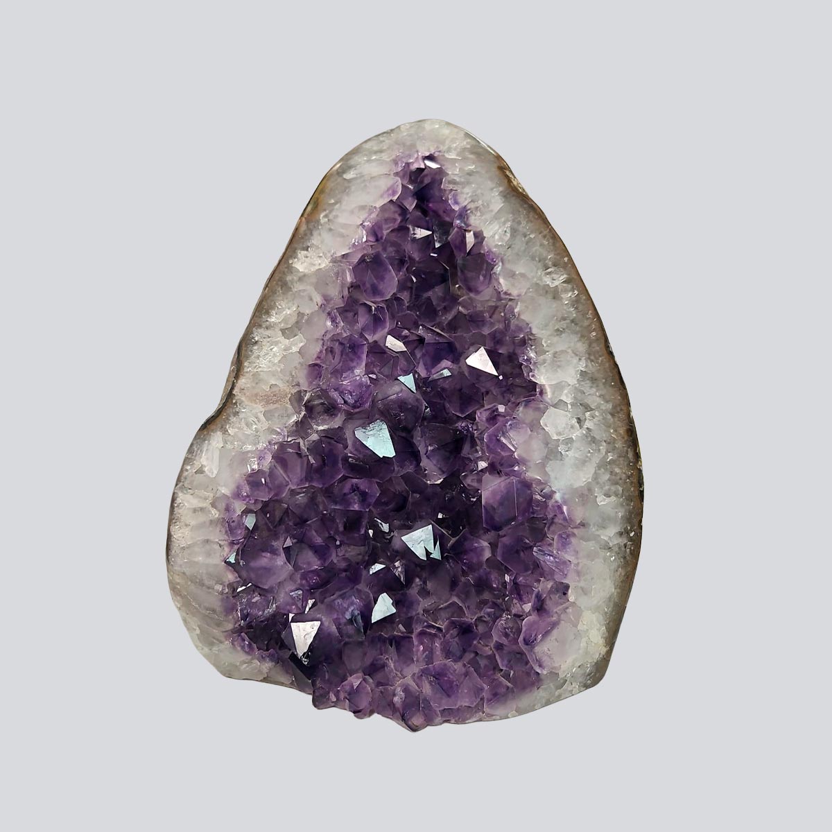 Front view of an amethyst crystal cluster featuring layered purple tones and a raw geode formation
