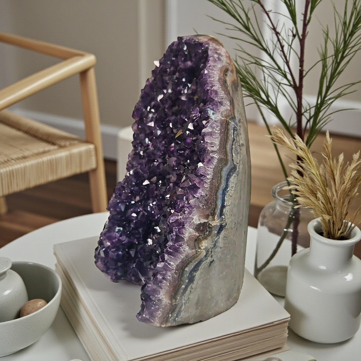 Upright amethyst cluster from Uruguay with rich purple crystals and strong light reflections highlighting its faceted surface.