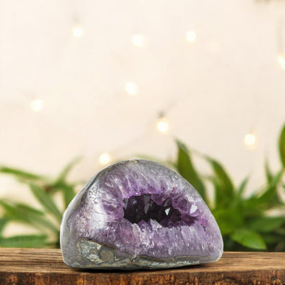 Dome-shaped amethyst geode from Uruguay featuring a dark central cavern and shimmering purple crystal bands.”