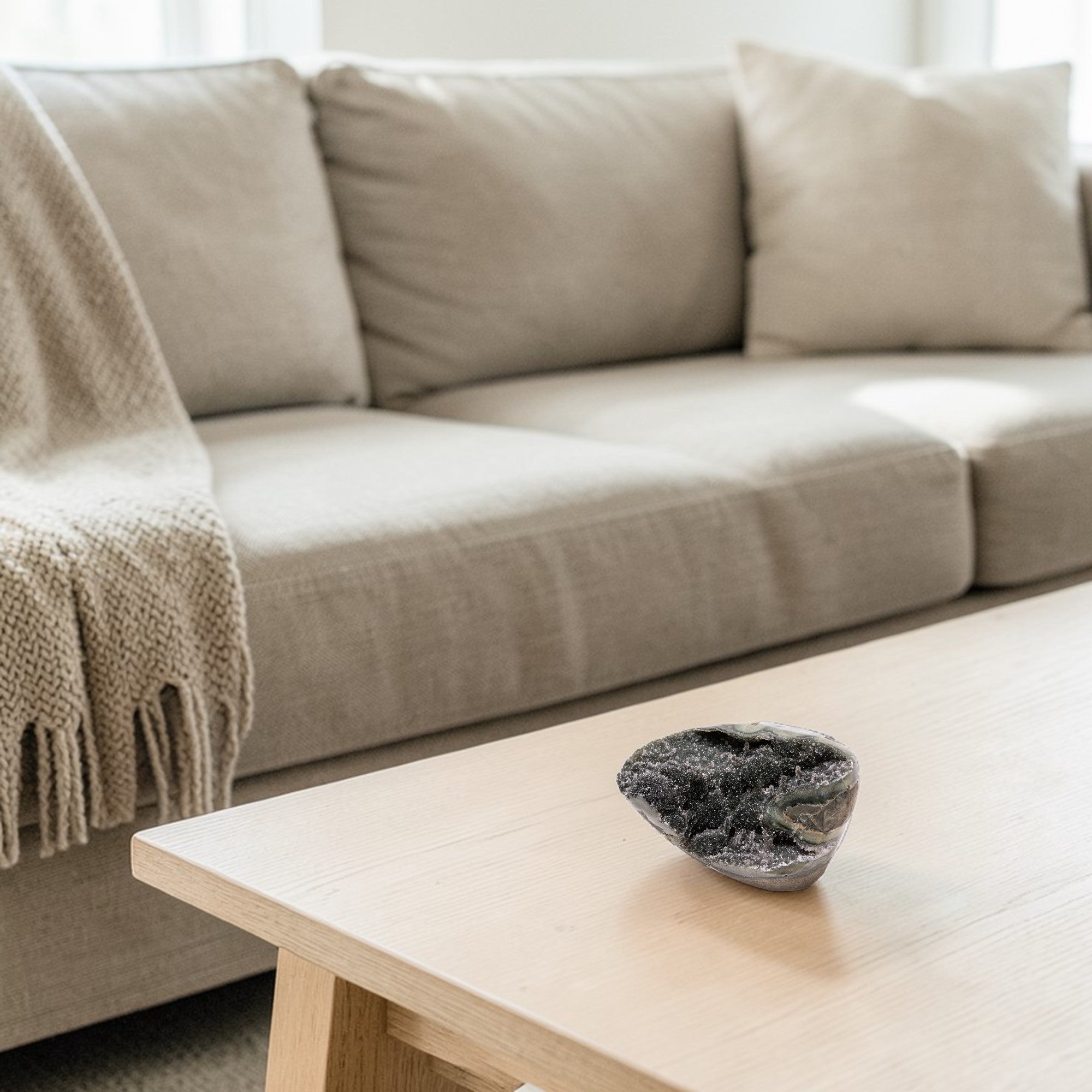Hand-sized druzy quartz geode with deep grey micro-crystal texture, visible chalcedony layers, and architectural silhouette suited for luxury neutral decor.