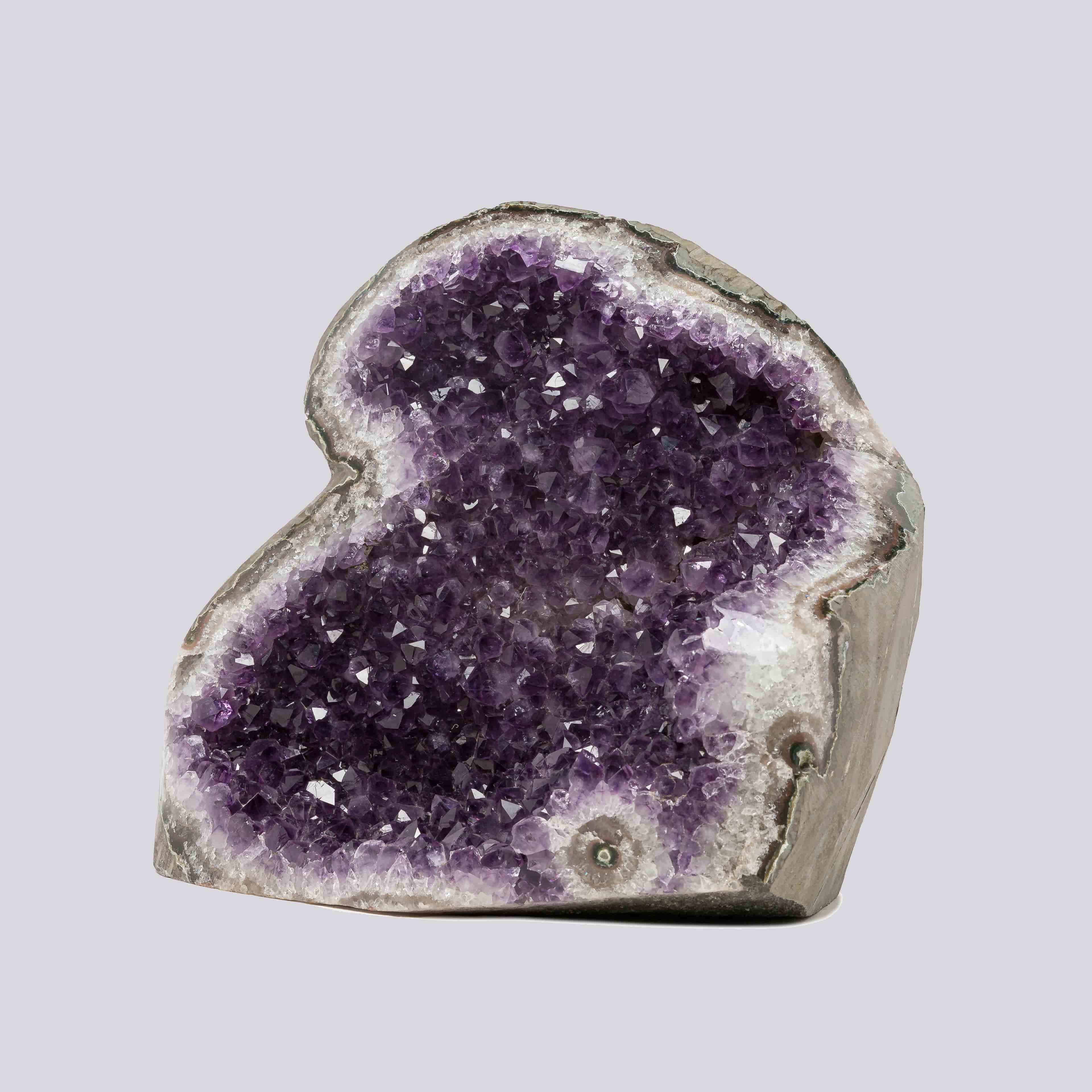 Striking Uruguayan amethyst geode featuring rich violet points and natural quartz banding, perfect for luxury interiors.