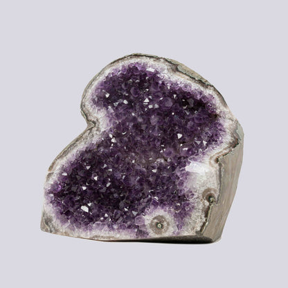 Striking Uruguayan amethyst geode featuring rich violet points and natural quartz banding, perfect for luxury interiors.