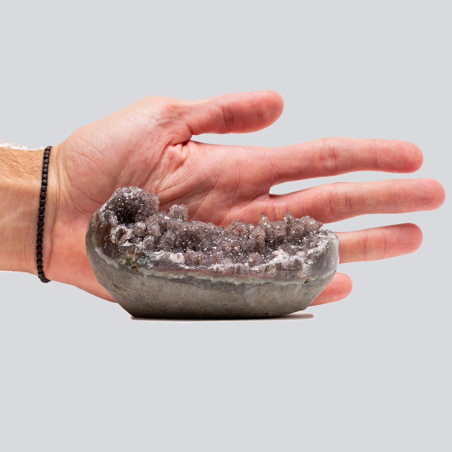 Small hand-size amethyst cluster in brown and rose tones with rounded crystal formations and a sparkling textured surface.