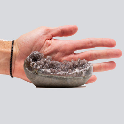 Small hand-size amethyst cluster in brown and rose tones with rounded crystal formations and a sparkling textured surface.