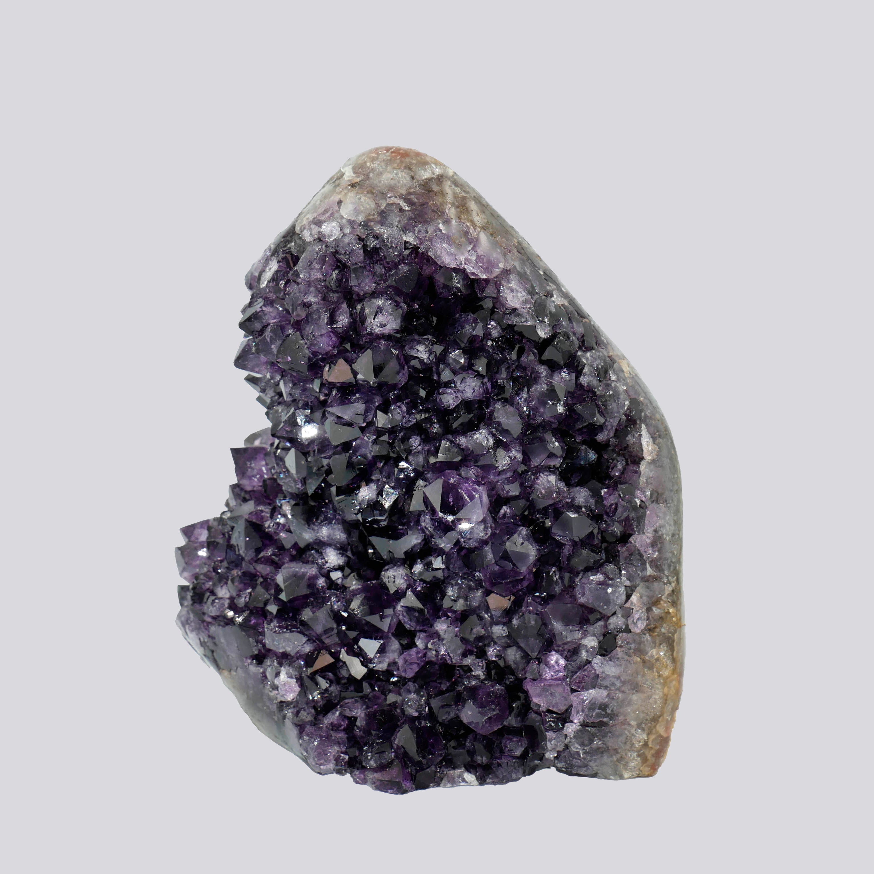 Upright Uruguayan amethyst geode with rich violet crystals and a smooth, rounded quartz-matrix top