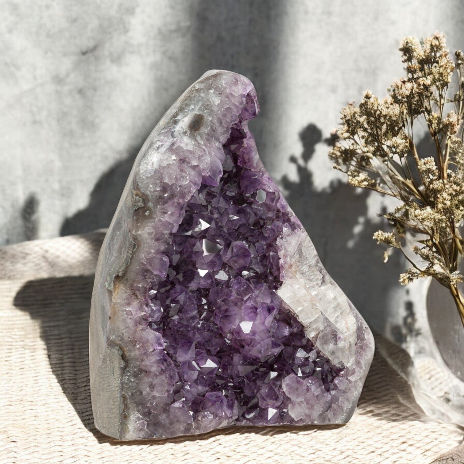 Deep-purple amethyst geode with clustered crystal points and a large white quartz section, ideal for refined home decor.