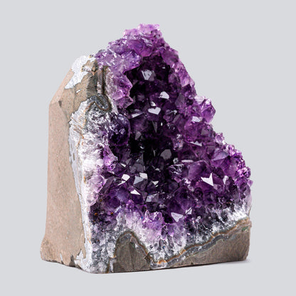Compact amethyst geode featuring rich purple crystals and a natural stone exterior, approximately 4–7 inches in height.