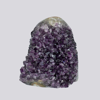 Tall deep-purple Uruguayan amethyst geode with dense crystal points and a natural rounded matrix top.