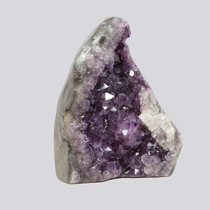 Uruguayan amethyst geode featuring rich violet crystals and a striking white quartz structure along the edge